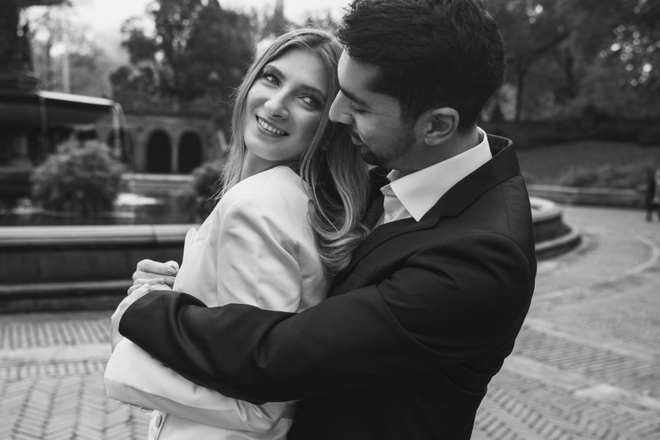 Sunny hugging Tanya with a loving stare in front of the Bethesda Fountain in Central Park, New York City